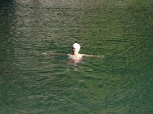 Paul is swimming in front of the cliff, where the water is smooth and looks lazy.